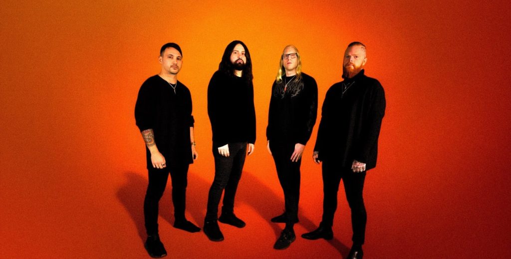 Born of Osiris band photo, 2025 lineup, progressive metalcore group on Sumerian Records, standing against orange background