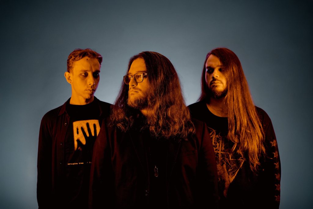 Stoned Jesus band photo – trio portrait with dramatic orange and blue lighting