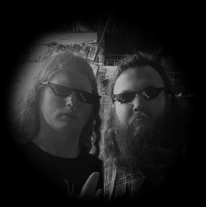 “Two members of Sodomised Cadaver wearing pixelated ‘deal with it’ sunglasses, posing together in a dark, vignetted black-and-white photo.”