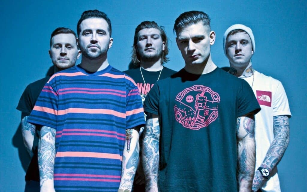 “Brutality Will Prevail band photo. Five members standing in a blue toned studio light, wearing casual streetwear and tattoos visible, looking directly at the camera.”