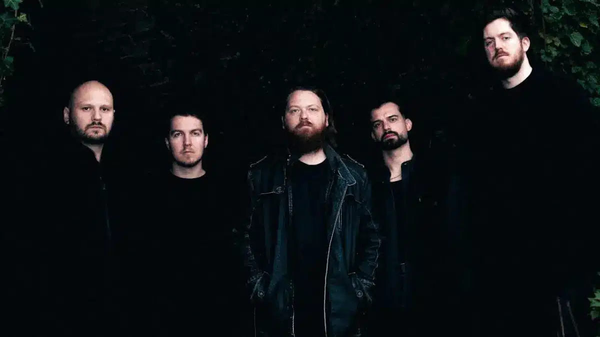 Dimscûa band portrait in dark outdoor setting with ivy-covered wall