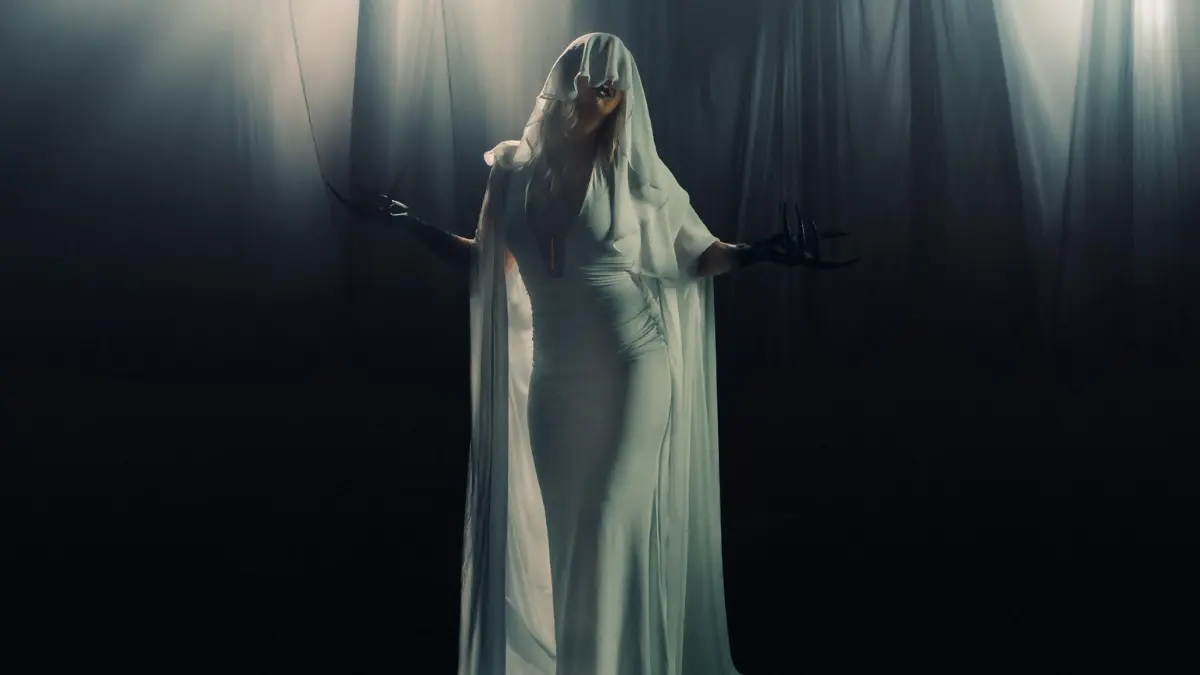 Cenobia metal artist performing in white veil and gown in dark cinematic music video scene