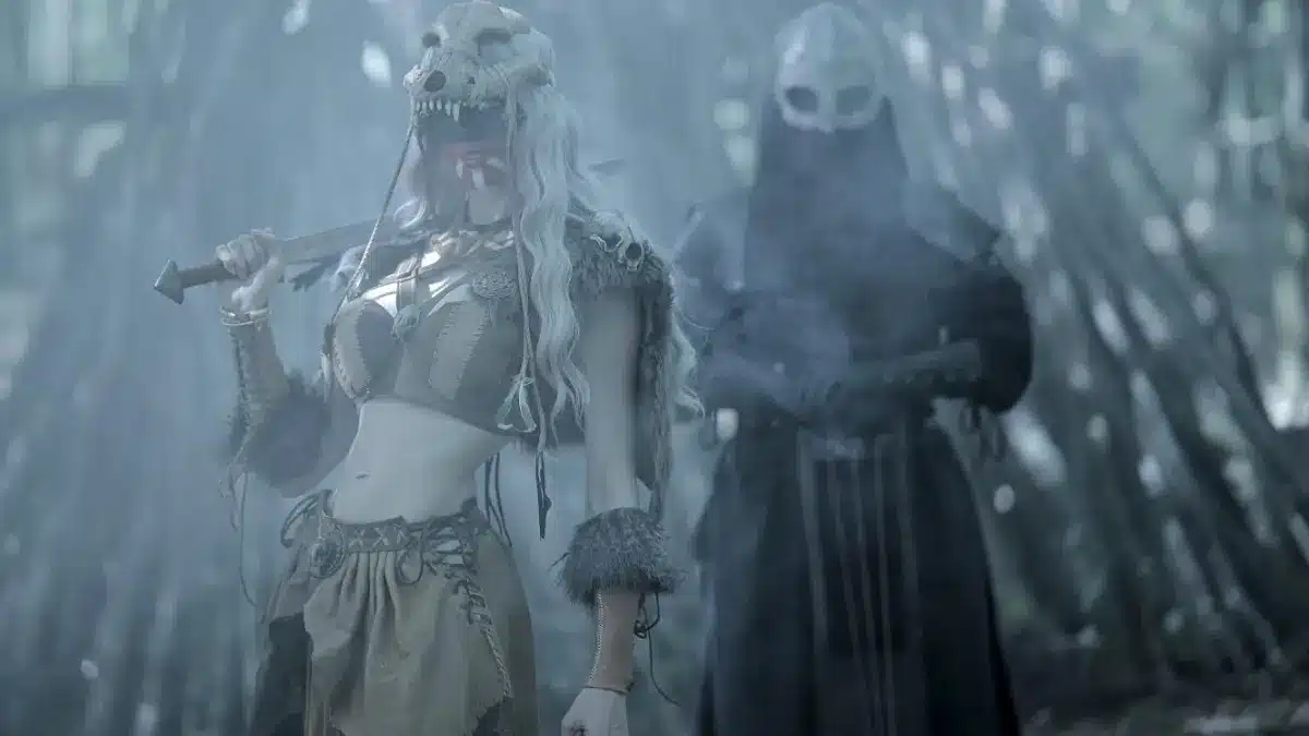 Eihwar interview featuring Asrunn and Mark in a forest ritual scene with warrior mask and ceremonial attire