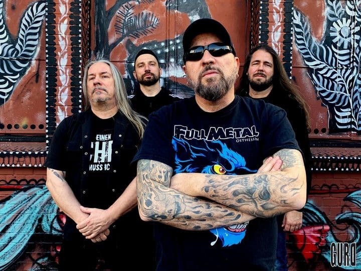 Swiss groove metal band Gurd posing in front of colorful street art mural for World Metal Weekly Switzerland edition