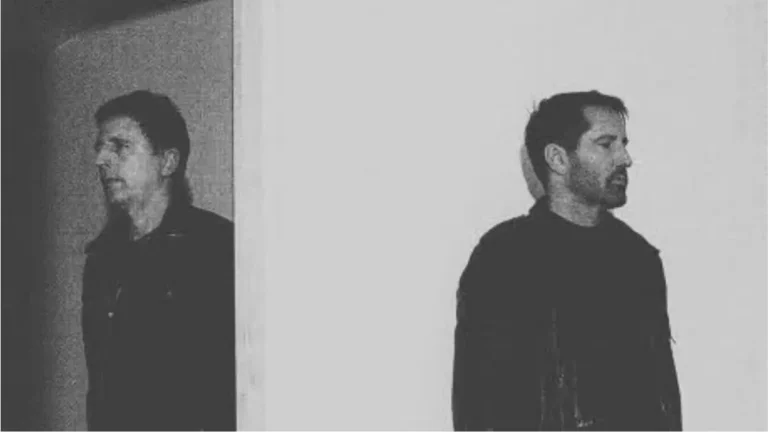 Atticus Ross and Trent Reznor of Nine Inch Nails standing in monochrome lighting during the band’s 2026 era.