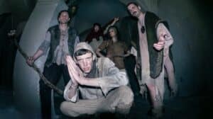 Members of Netherwilds pose in medieval-inspired costumes inside a stone building, reflecting the band's fantasy folk aesthetic.