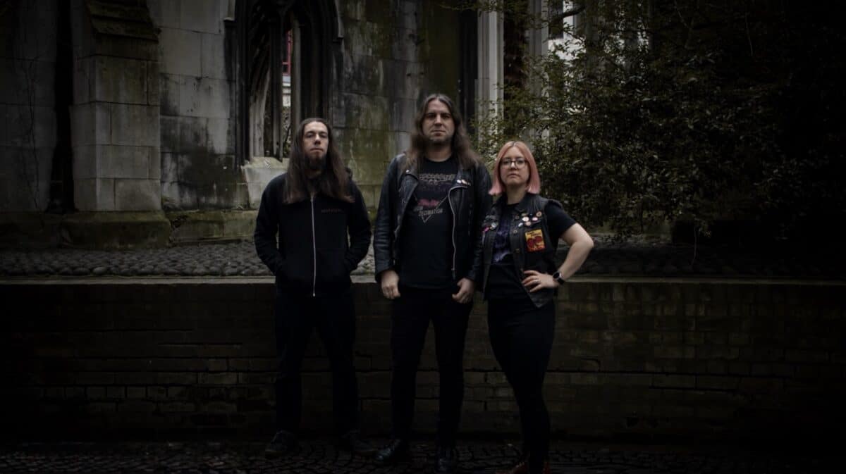 British doom metal band Witchsorrow posing outside a weathered Gothic stone building ahead of the release of The Devil and All His Works.