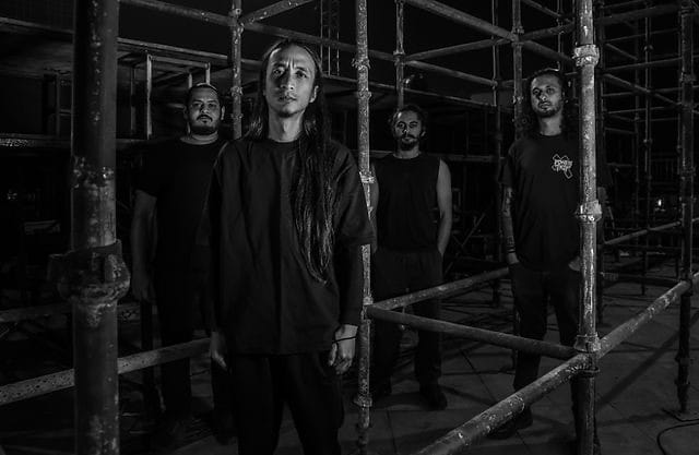 Godless band members photographed in black and white among industrial metal scaffolding