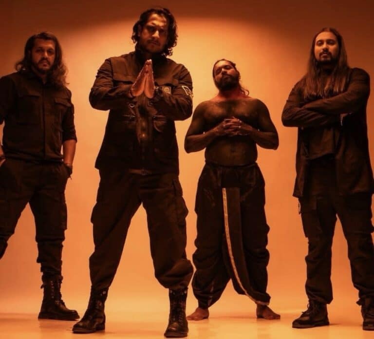 Zygnema band members posing against an orange background in dark clothing