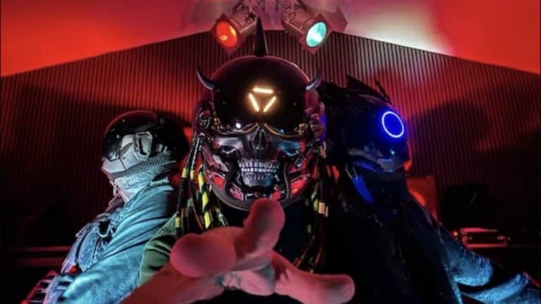 iAtlas band photo featuring three members in futuristic helmets under red stage lighting