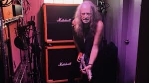 Joe Hasselvander Armor Plating studio photo showing Hasselvander playing guitar beside Marshall amplifiers