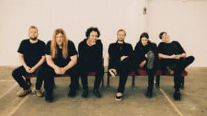 Zeal & Ardor Carpenter Brut remix announcement featuring all six band members seated together in a promotional photograph.
