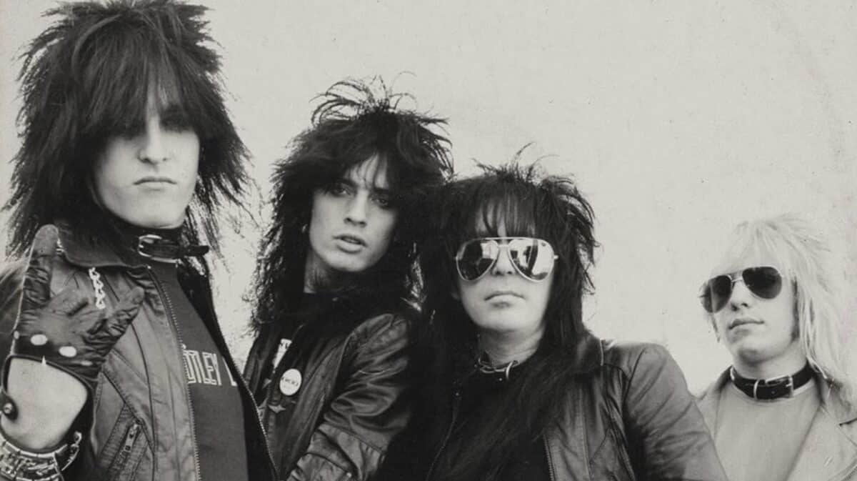 Mötley Crüe Take Me To The Top era band photo featuring Nikki Sixx, Tommy Lee, Vince Neil and Mick Mars in their early 1980s glam metal style.