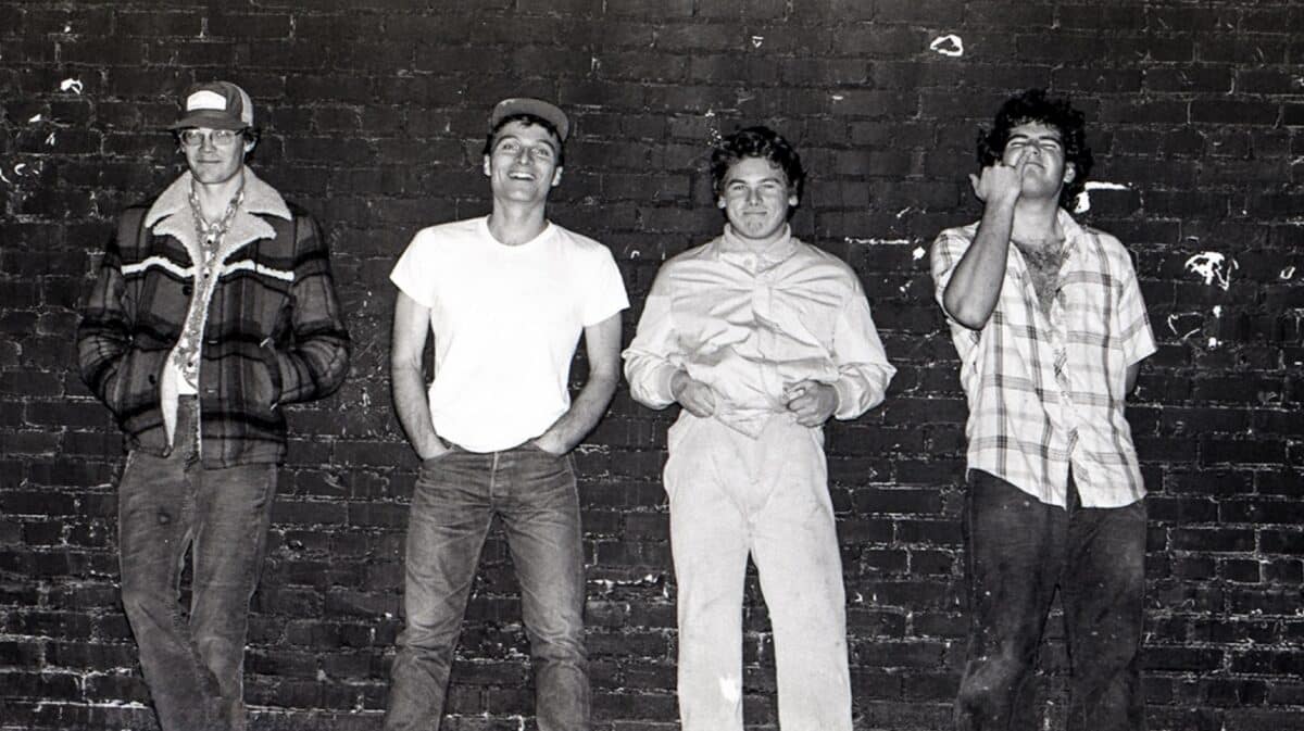 Descendents Milo Goes to Comics announcement featuring a vintage black-and-white photograph of the punk rock band standing against a brick wall.