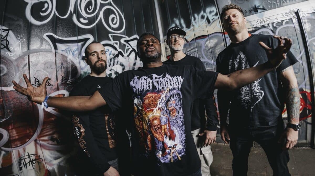 Leng Tch’e Hammered Into Collapse EP Review featuring the Belgian grindcore band posing together in front of a graffiti-covered wall.